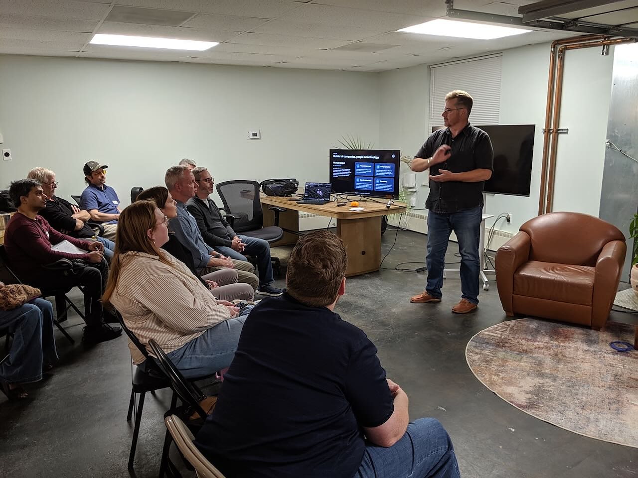 About ten people listening to a talk at the October AI Builders Meetup