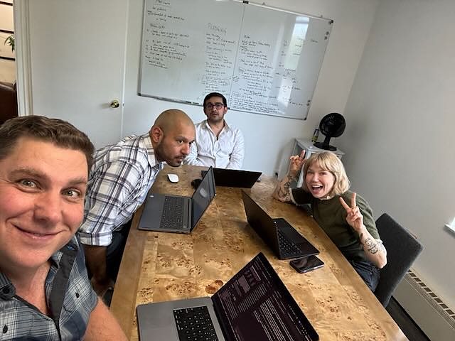 Members working on laptops around the conference room table