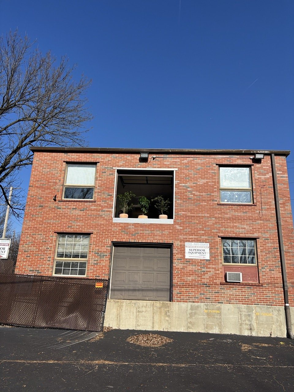 The brick back of the building, with the second-floor garage-door window