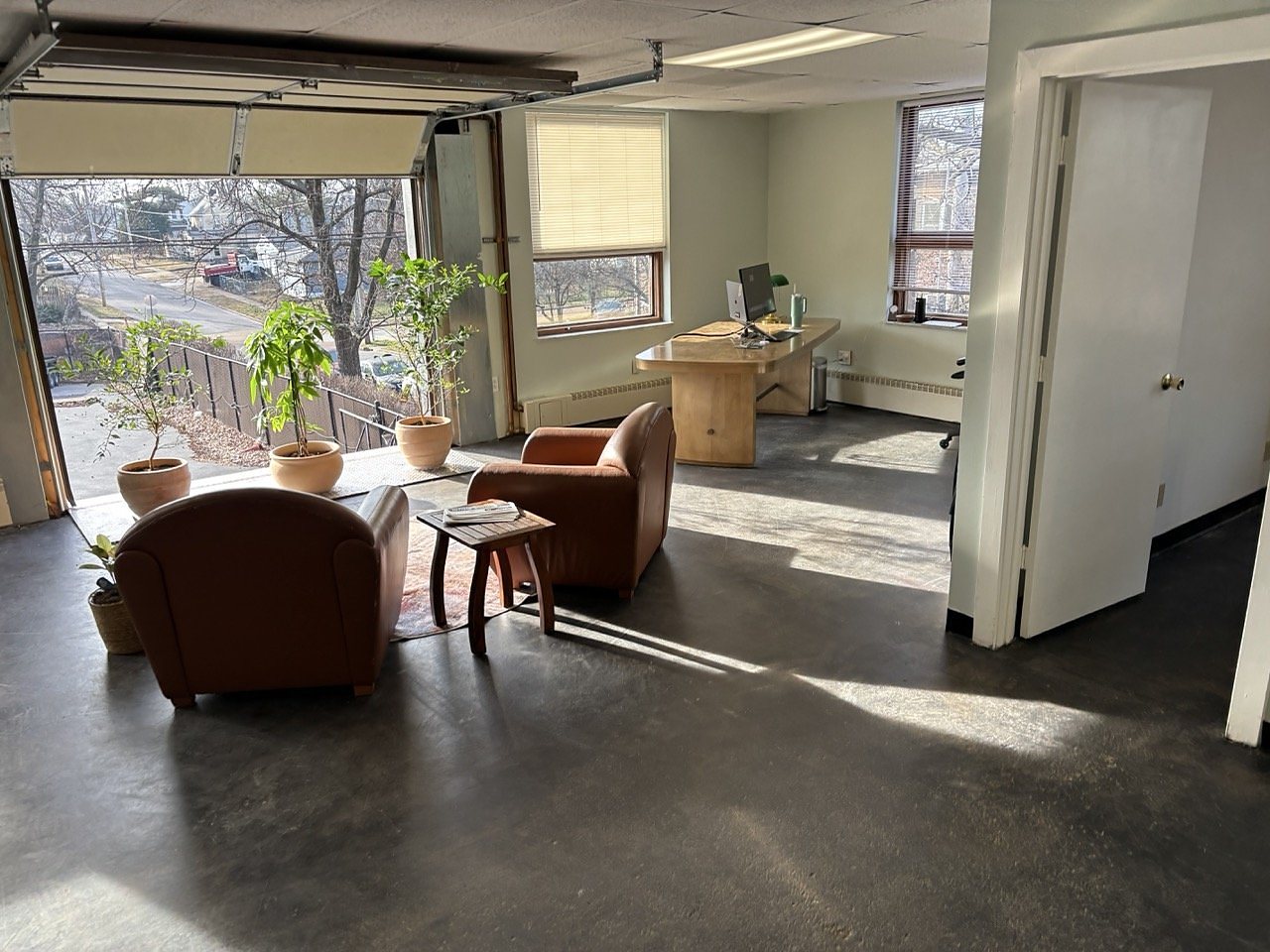 Leather armchairs in the sunny main room with the garage door open