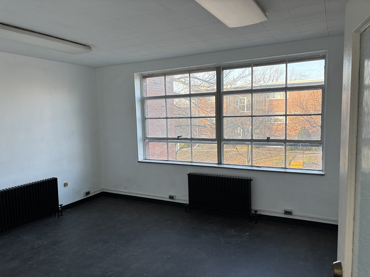 Empty private office with a wall of large industrial windows